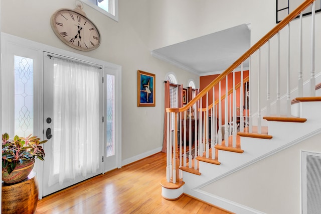 foyer entrance featuring light wood-type flooring and ornamental molding