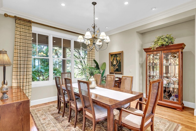 dining room with an inviting chandelier, crown molding, and light hardwood / wood-style flooring