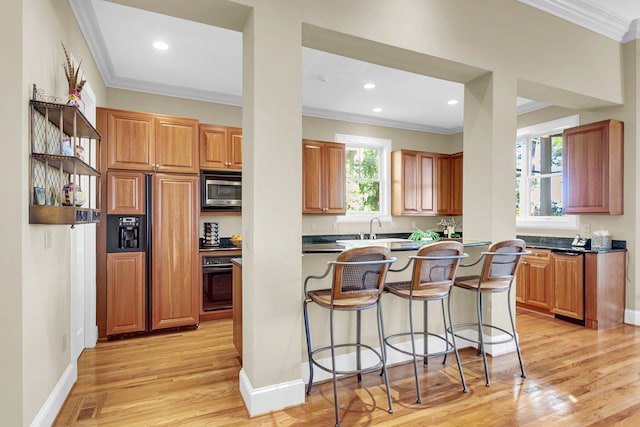 kitchen featuring a wealth of natural light, built in appliances, and ornamental molding