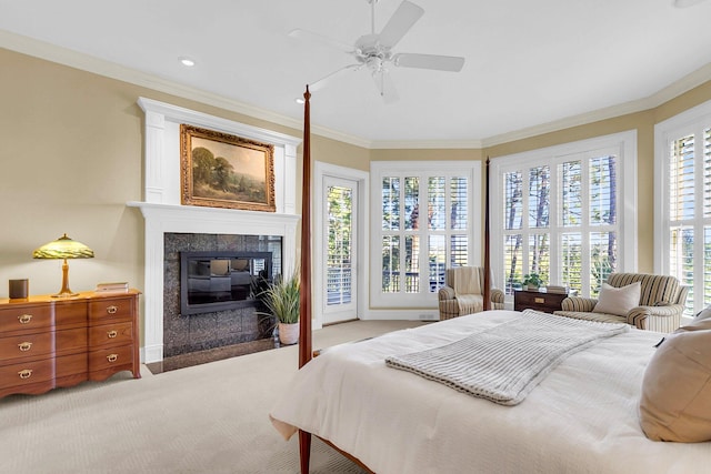 carpeted bedroom featuring ceiling fan, a tile fireplace, access to exterior, and ornamental molding