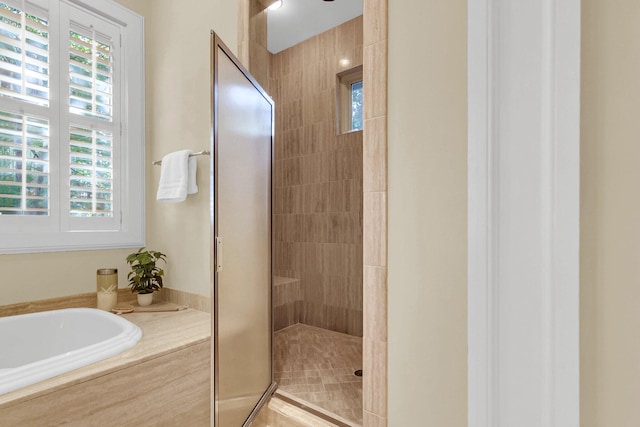 bathroom featuring shower with separate bathtub