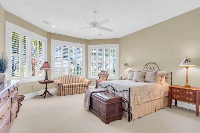 bedroom featuring light carpet, multiple windows, and ceiling fan