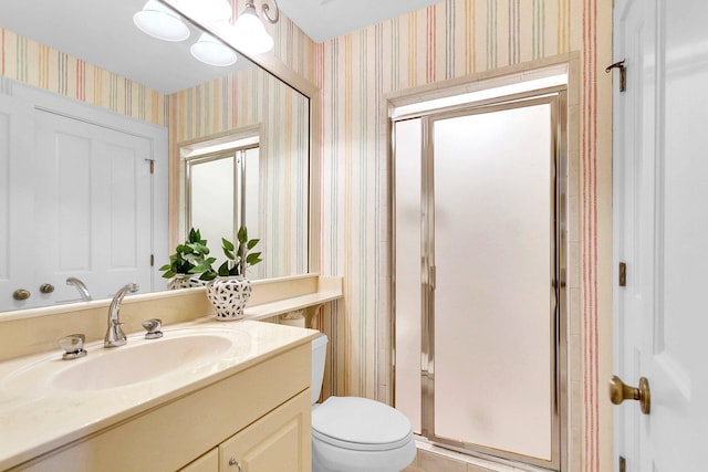 bathroom with a shower with shower door, toilet, and vanity