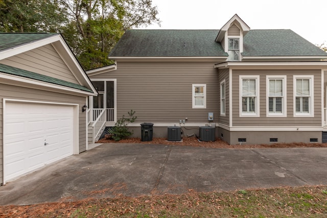 view of property exterior with a garage and cooling unit