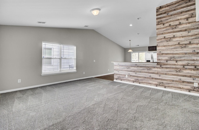 unfurnished living room with lofted ceiling and carpet floors