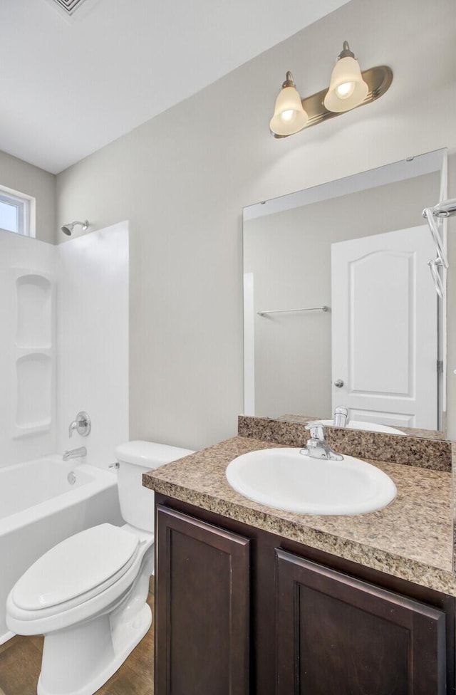 full bathroom with toilet, wood-type flooring, vanity, and shower / bath combination