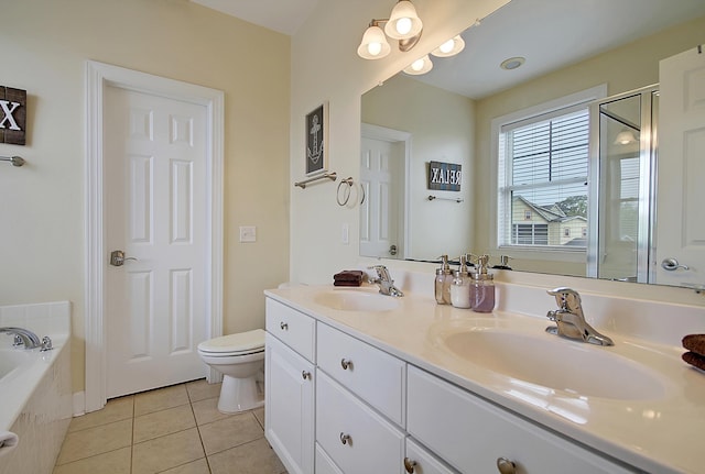 bathroom with vanity, tile patterned flooring, a relaxing tiled tub, and toilet