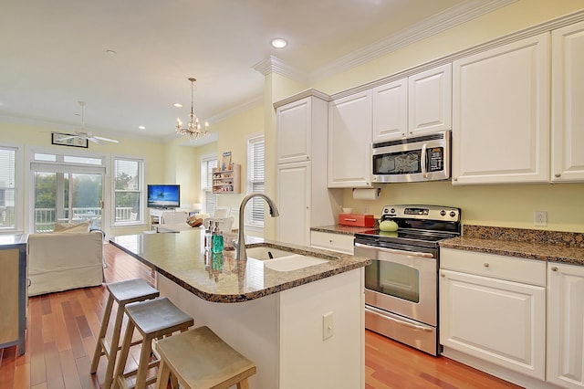 204 Michigan Ave Unit D2, Folly Beach, SC 29439 - kitchen featuring appliances with stainless steel finishes, a sink, open floor plan, light wood-type flooring, and ornamental molding