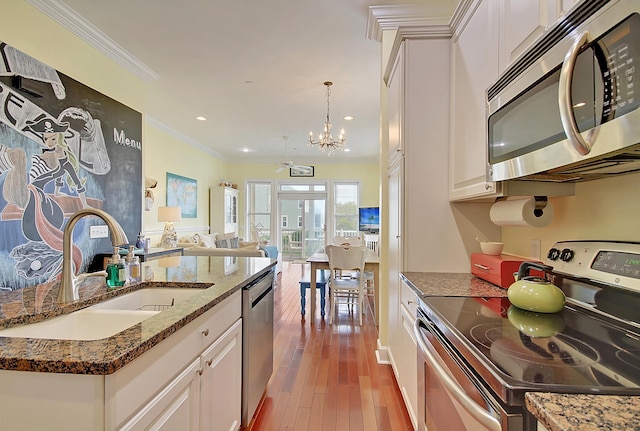 204 Michigan Ave Unit D2, Folly Beach, SC 29439 - kitchen featuring appliances with stainless steel finishes, a sink, a chandelier, open floor plan, and white cabinetry