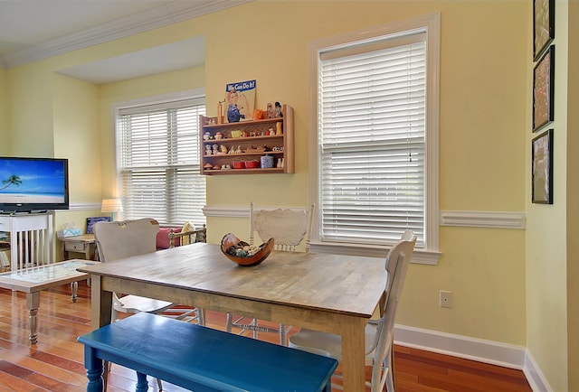 dining space featuring hardwood / wood-style flooring and crown molding