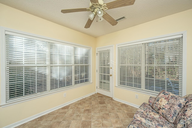 unfurnished room with a textured ceiling and ceiling fan