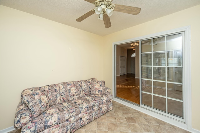 sitting room with ceiling fan and a textured ceiling