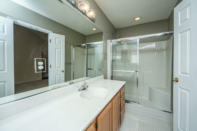 bathroom featuring walk in shower, tile patterned floors, vanity, and a textured ceiling