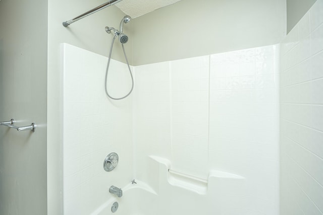 bathroom featuring tiled shower / bath and a textured ceiling