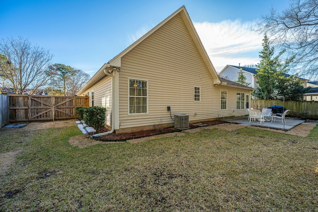 back of property with a yard, central air condition unit, and a patio area