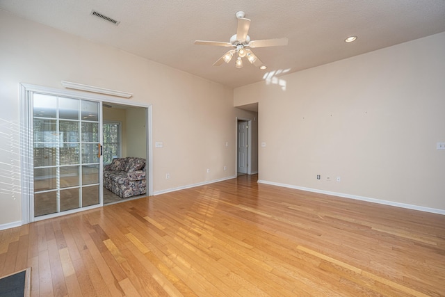 unfurnished room featuring ceiling fan, light hardwood / wood-style floors, and a textured ceiling