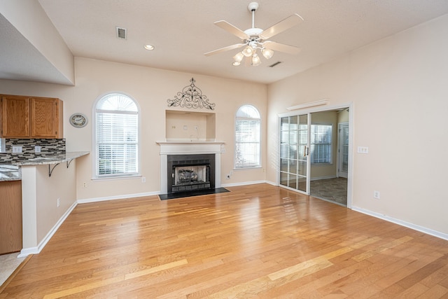 unfurnished living room featuring light hardwood / wood-style flooring and ceiling fan