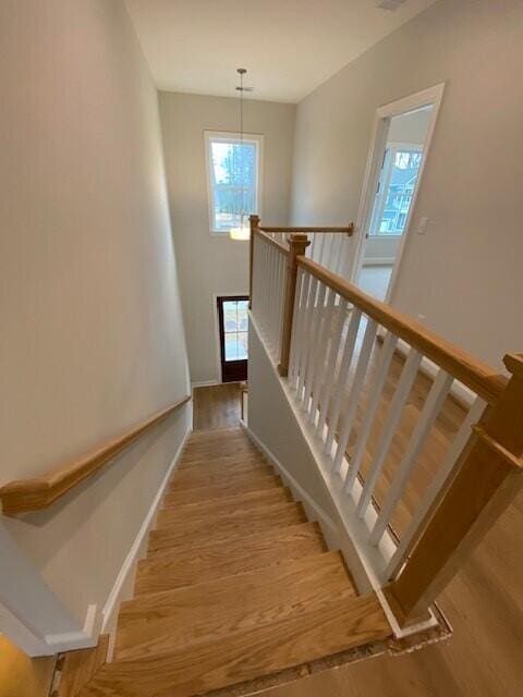 stairs featuring baseboards and wood finished floors