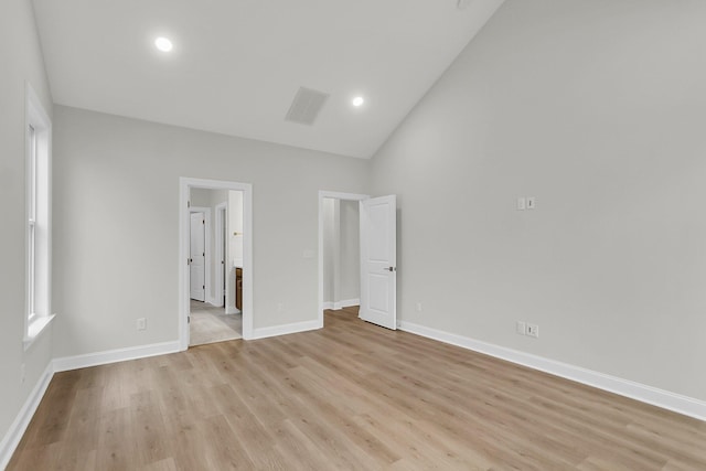 unfurnished bedroom featuring light wood finished floors, baseboards, visible vents, ensuite bath, and recessed lighting