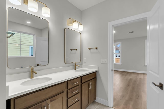 full bathroom with visible vents, a sink, baseboards, and double vanity