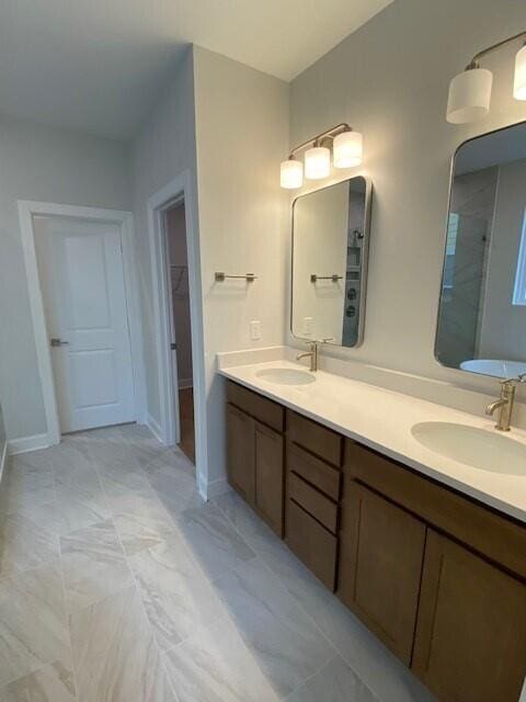 full bathroom with a walk in closet, double vanity, a sink, and walk in shower