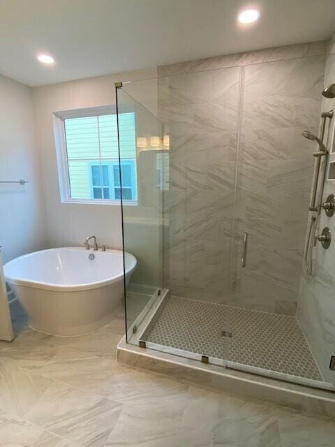 bathroom with a stall shower and a soaking tub