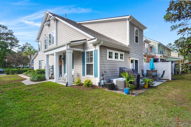 rear view of house featuring a yard and a patio area