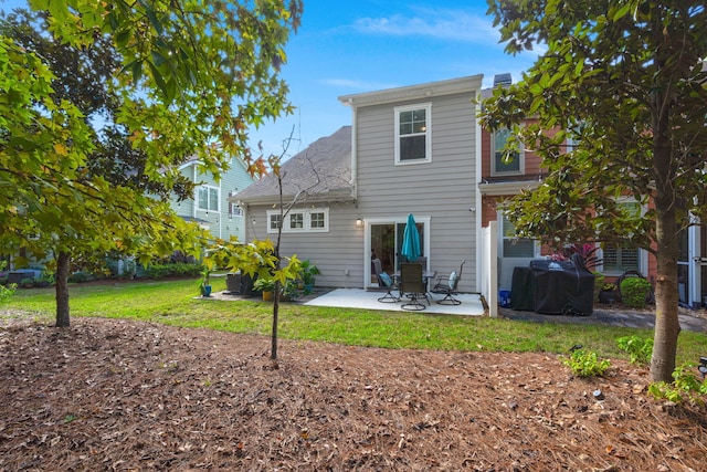 back of property with a yard and a patio