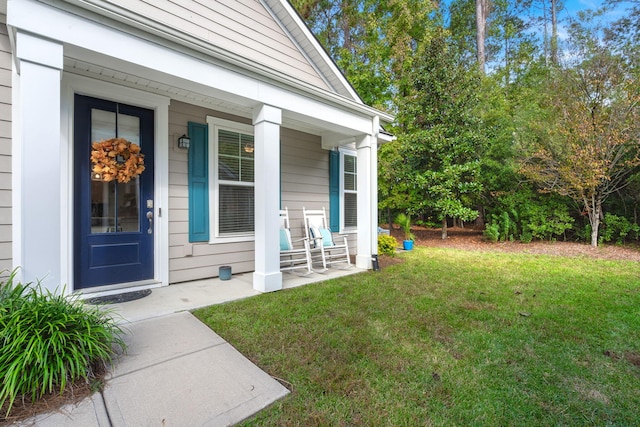 property entrance with a lawn and covered porch