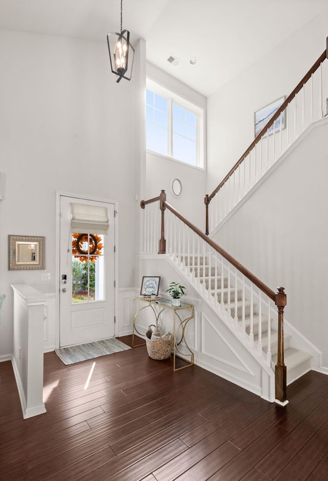 entrance foyer featuring a high ceiling, dark hardwood / wood-style floors, and an inviting chandelier