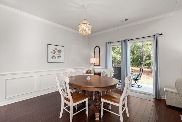 dining room with crown molding, dark wood-type flooring, and a chandelier