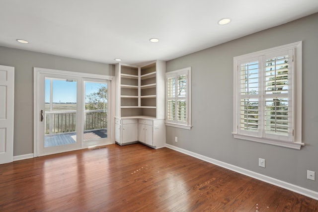 empty room with recessed lighting, visible vents, baseboards, and wood finished floors