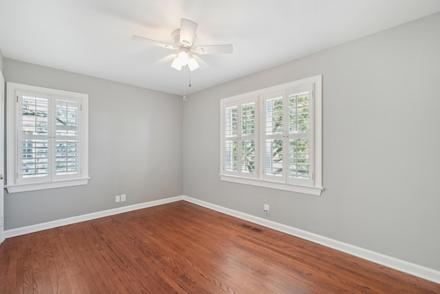 spare room featuring ceiling fan, wood finished floors, visible vents, and baseboards