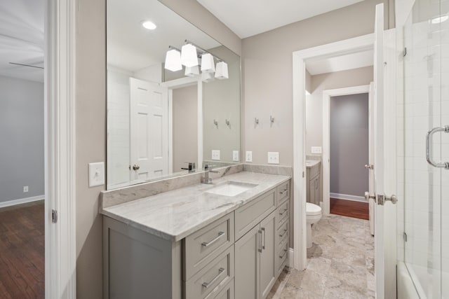 bathroom with toilet, vanity, and baseboards