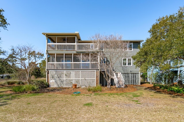 rear view of house featuring a yard, a sunroom, ceiling fan, and stairs