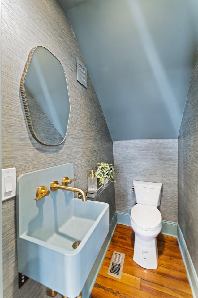 80 Smith St, Charleston, SC 29401 - bathroom featuring lofted ceiling, toilet, wood finished floors, baseboards, and a sink