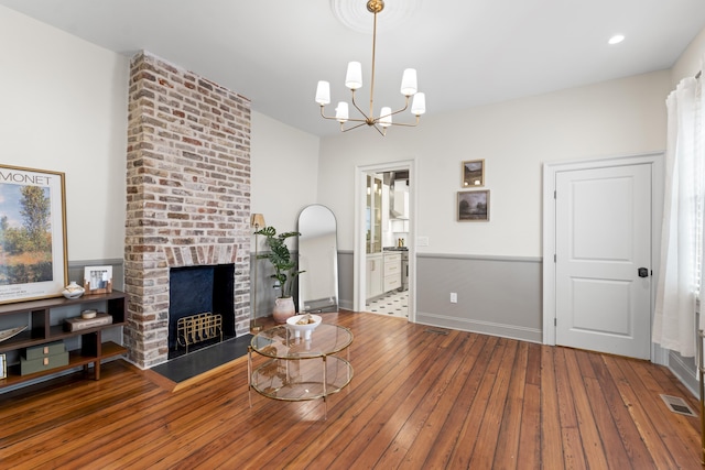 80 Smith St, Charleston, SC 29401 - living room featuring hardwood / wood-style floors, a chandelier, and a brick fireplace