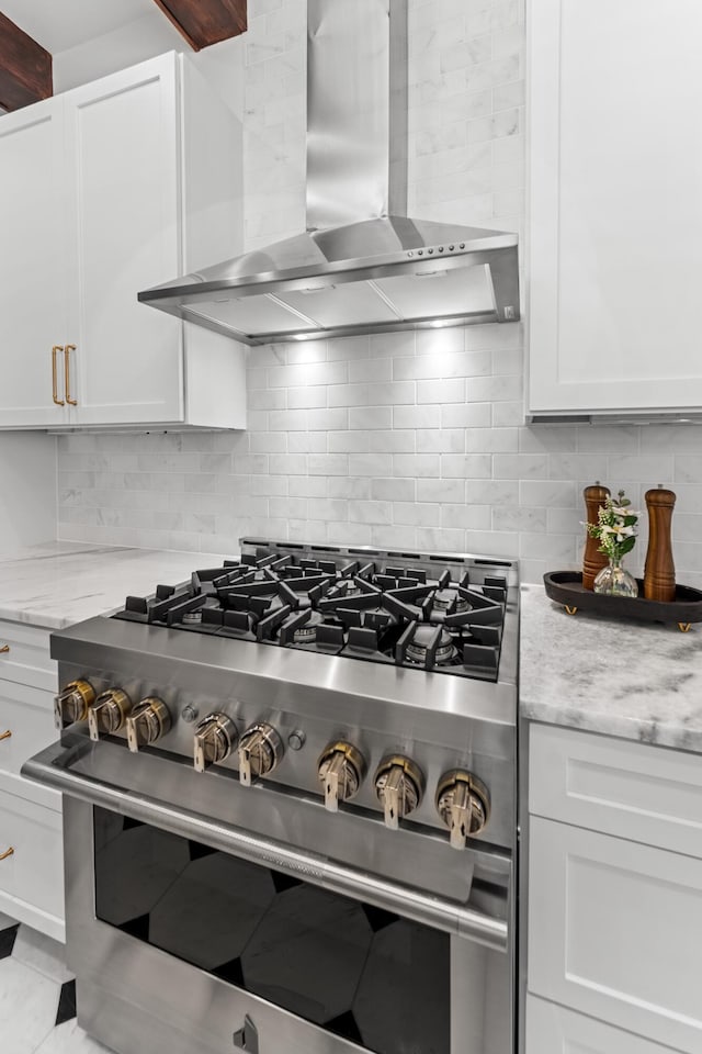 80 Smith St, Charleston, SC 29401 - kitchen with stainless steel range, wall chimney exhaust hood, white cabinetry, and backsplash