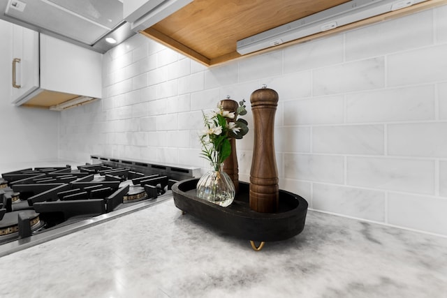 80 Smith St, Charleston, SC 29401 - kitchen view of cooktop, range hood, decorative backsplash, light countertops, and white cabinets