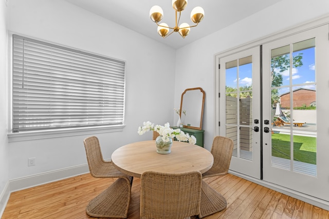 80 Smith St, Charleston, SC 29401 - dining room with a chandelier, french doors, light wood finished floors, and baseboards