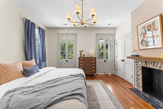 80 Smith St, Charleston, SC 29401 - bedroom featuring wood finished floors, a chandelier, recessed lighting, and a brick fireplace