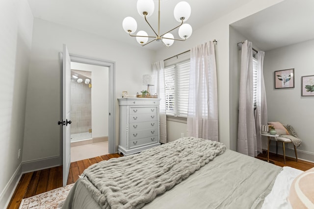 80 Smith St, Charleston, SC 29401 - bedroom with a chandelier, wood finished floors, baseboards, and connected bathroom