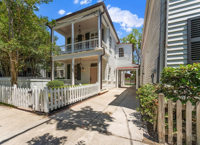 80 Smith St, Charleston, SC 29401 - greek revival inspired property featuring a balcony, covered porch, a fenced front yard, and driveway