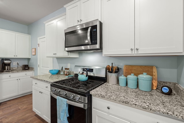 kitchen featuring white cabinetry, wood finished floors, and stainless steel appliances