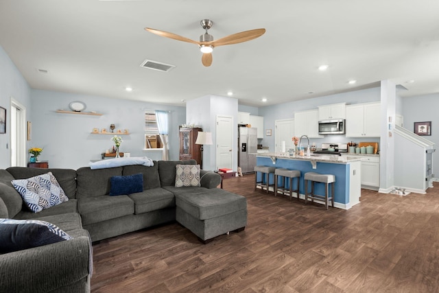 living area with dark wood-style floors, baseboards, visible vents, recessed lighting, and ceiling fan