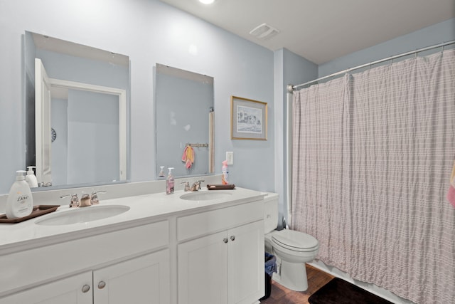 full bath featuring double vanity, toilet, wood finished floors, and a sink