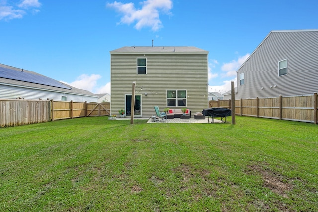 back of property featuring a patio, a lawn, a fenced backyard, and an outdoor hangout area