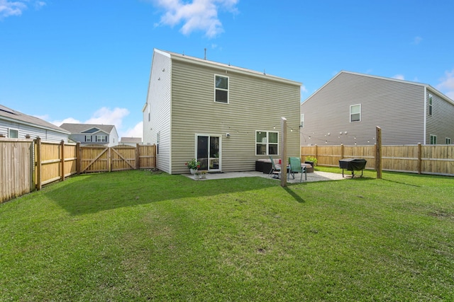 rear view of property featuring a gate, a yard, a patio area, and a fenced backyard