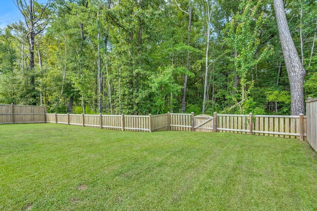 view of yard with a fenced backyard and a gate