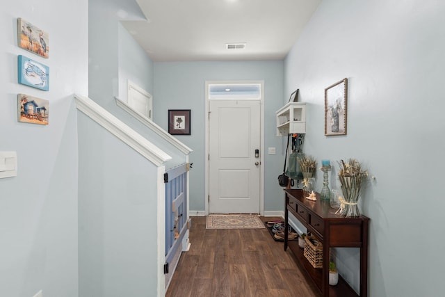 foyer featuring dark wood-style floors, visible vents, and baseboards